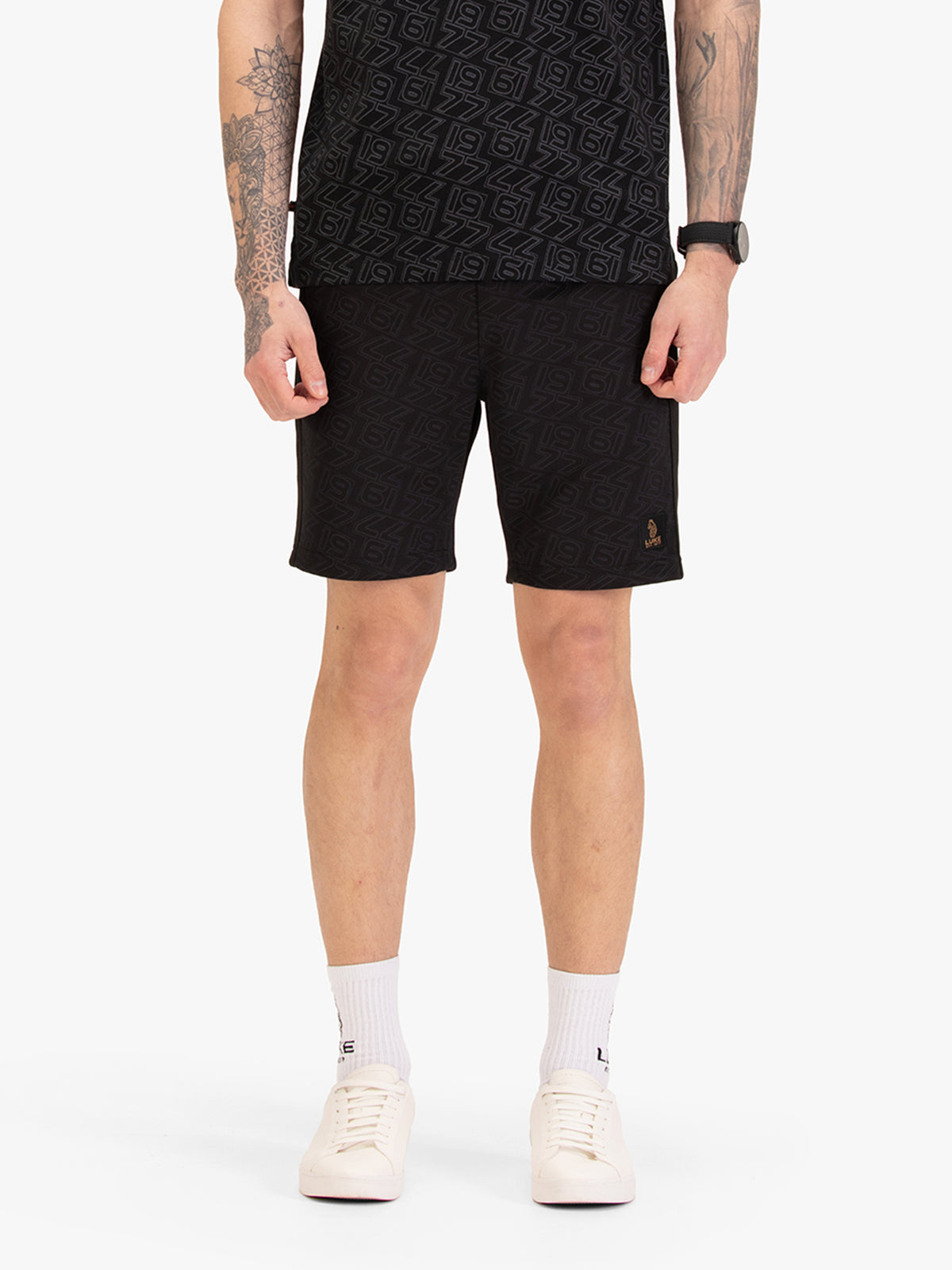 Men's black shorts with drawstring waistband, worn by a model, front view
