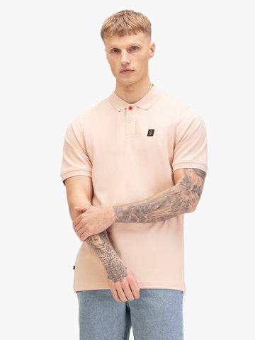 Men's pink polo shirt with polo collar, worn by a model, front view