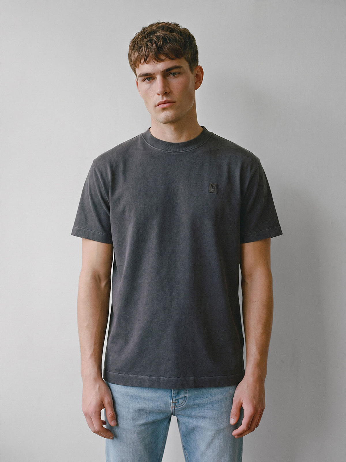 Man wearing dark charcoal LUKE 1977 Nord relaxed fit dyed t-shirt with jeans, front view