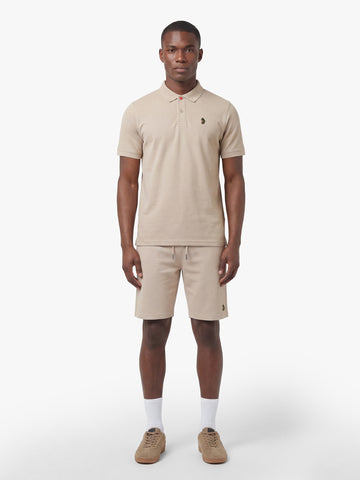 Men's beige short set with short-sleeve shirt and drawstring shorts, worn by model.